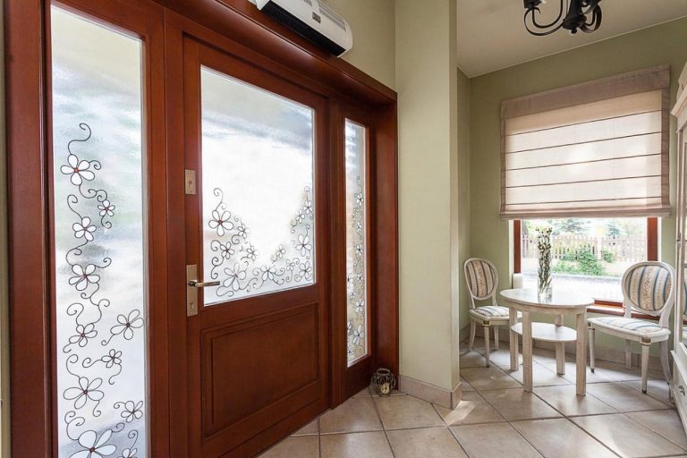 Reinforced wooden safety door with frosted glass panels in a Dubai home entryway